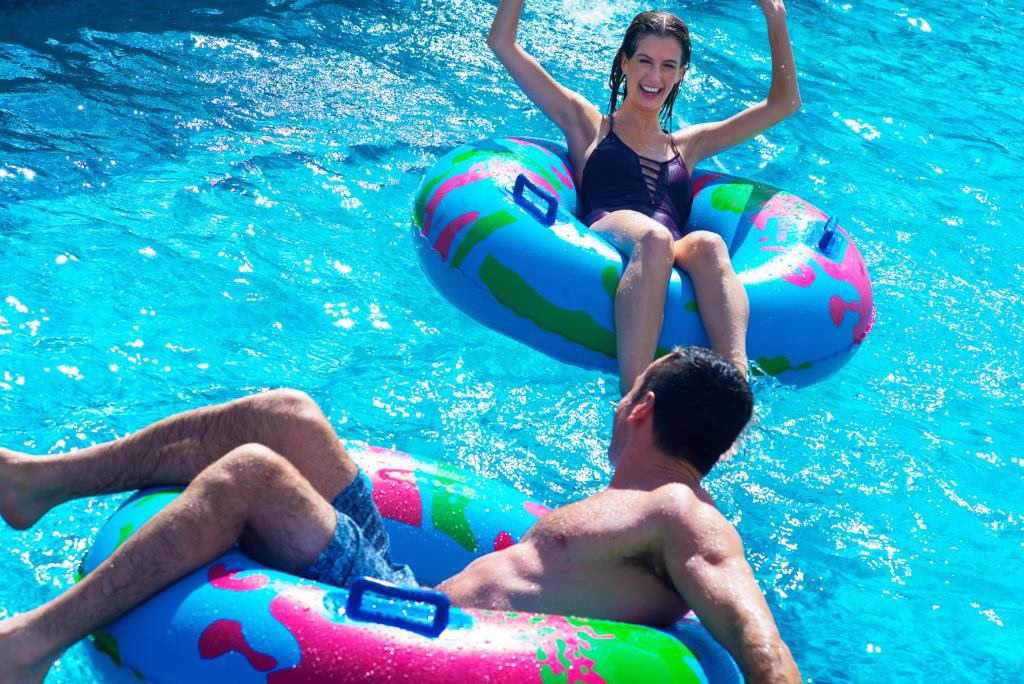 a man and a woman sitting on inflatables in the lazy river at Royalton Bavaro, An Autograph Collection All-Inclusive Resort & Casino in Punta Cana