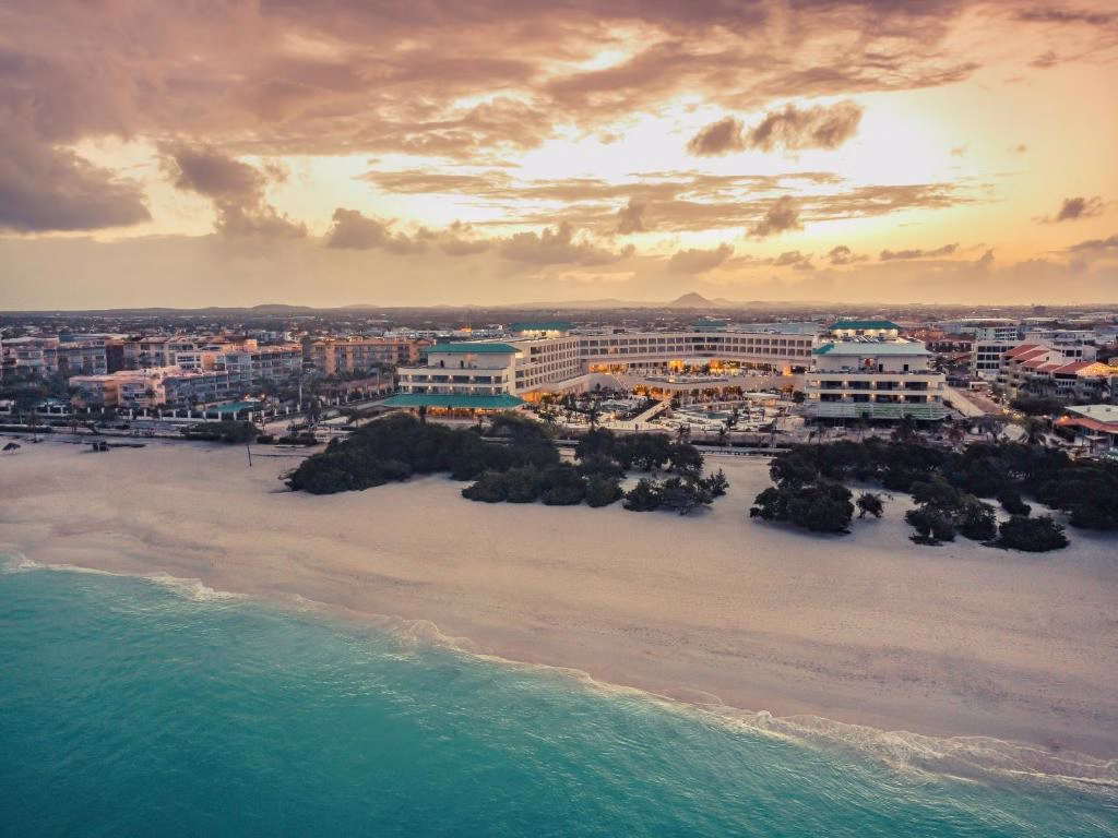 an aerial view of a beach with buildings and the ocean at JOIA Aruba by Iberostar in Palm-Eagle Beach Caribbean